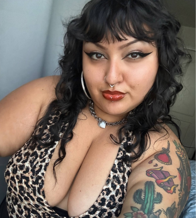 Mistress Dahlia wearing a low cut top